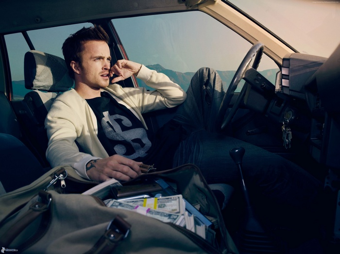 Aaron Paul in a car with a bag of money