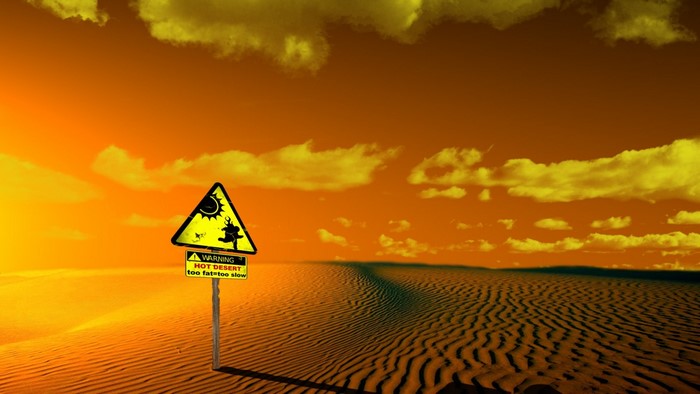 Warning sign in a hot desert landscape at sunset