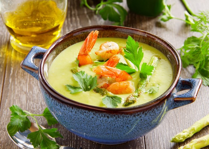 Creamy asparagus soup with shrimp and parsley