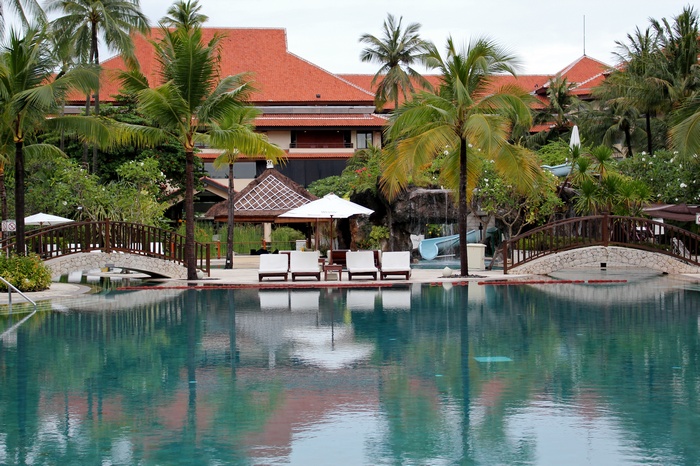 Resort pool with bridges and palm trees in Indonesia