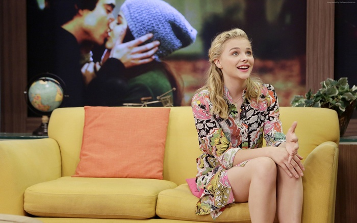 Chloe Moretz on a yellow couch