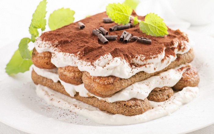 Tiramisu dessert with cocoa powder and mint leaves