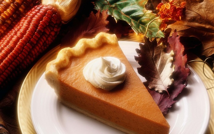 Slice of pumpkin pie with whipped cream and autumn decorations
