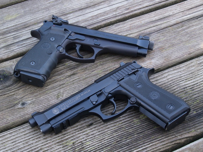 Two handguns on a wooden surface