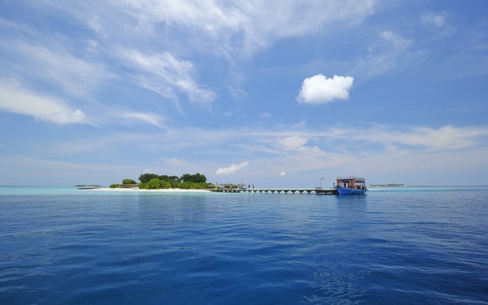 Island with a pier and a boat in the ocean