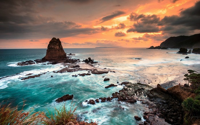 Sunset over rocky coast with ocean waves
