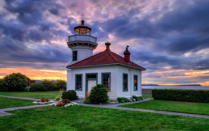 White lighthouse with red roof at sunset