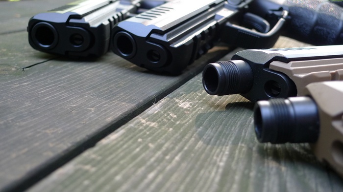 Multiple handguns on a wooden table