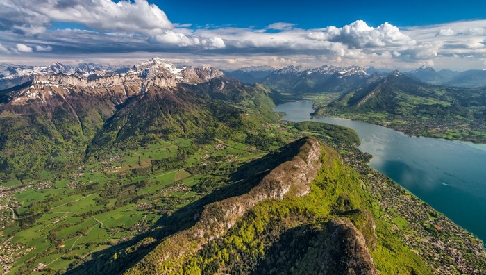 Aerial view of a mountain range and lake in the Alps