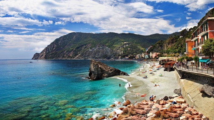 Coastal town with beach and rocky mountain overlooking the sea