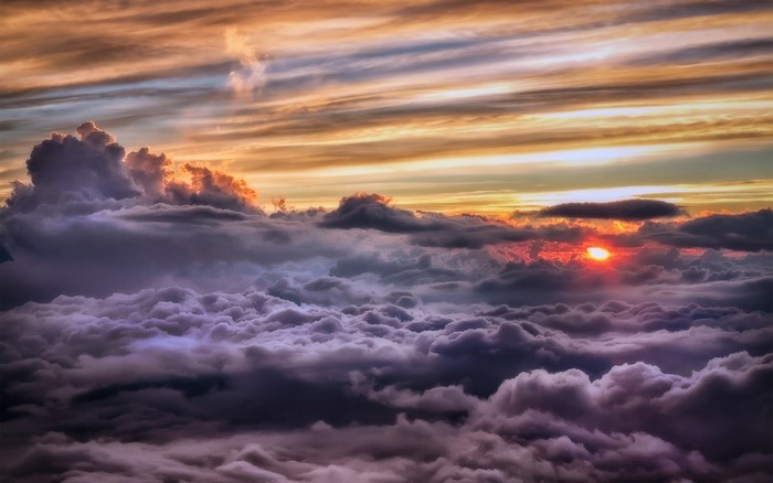 Sunset over clouds with orange and purple hues