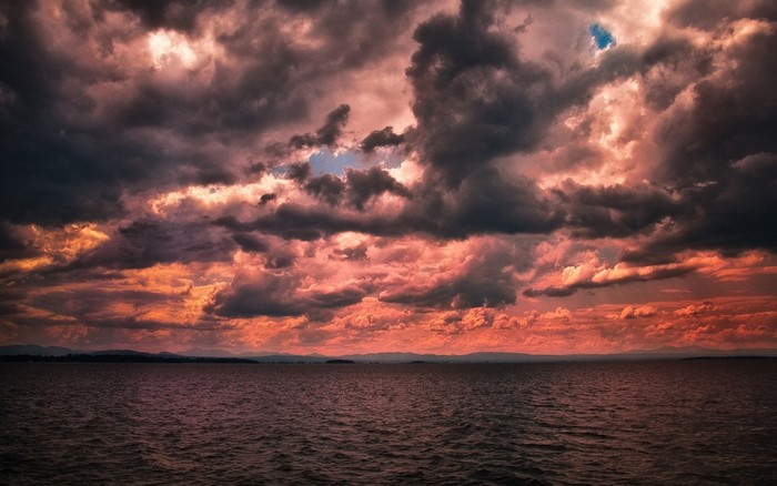 Dramatic sunset over the ocean with dark clouds
