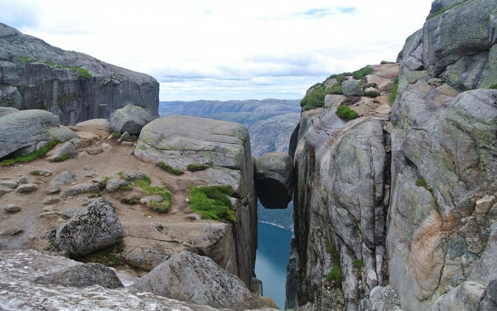 Kjeragbolten boulder wedged between cliffs overlooking a fjord