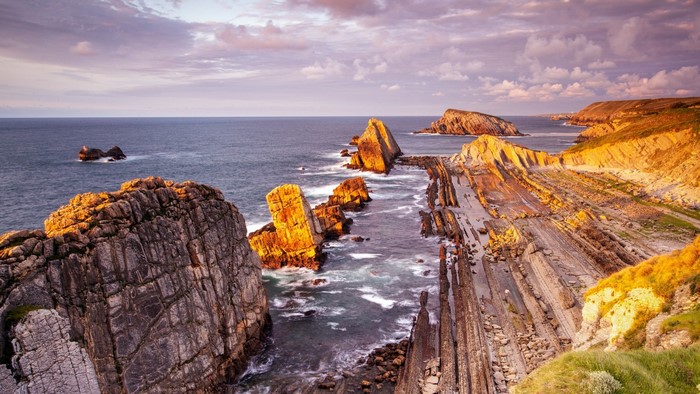 Rocky coast at sunset with waves crashing
