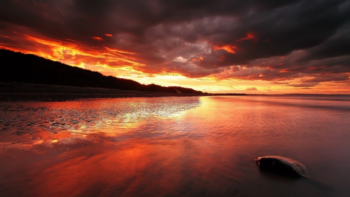 Dramatic sunset over a calm sea and shore