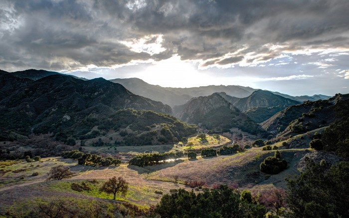 Mountain valley with dramatic clouds at sunset