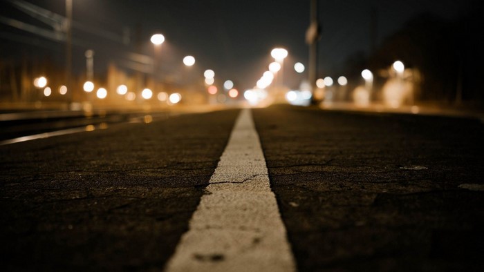 Empty road at night with streetlights and bokeh