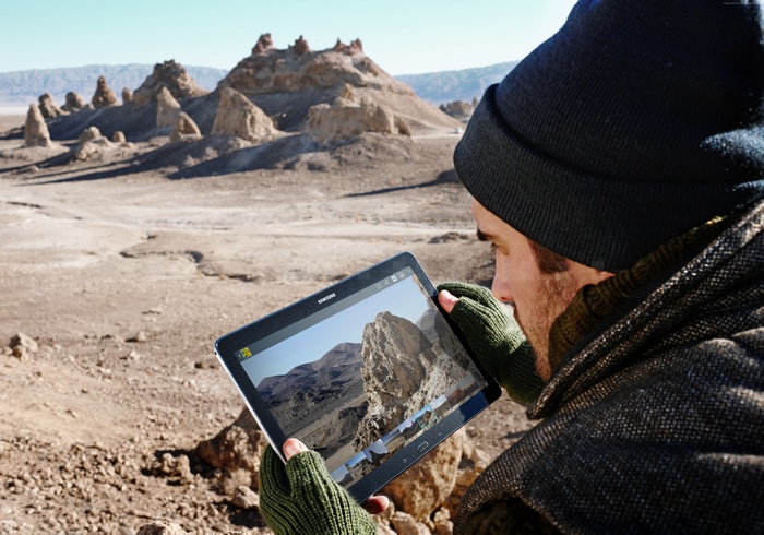 Man with Samsung Galaxy Tab S in desert landscape