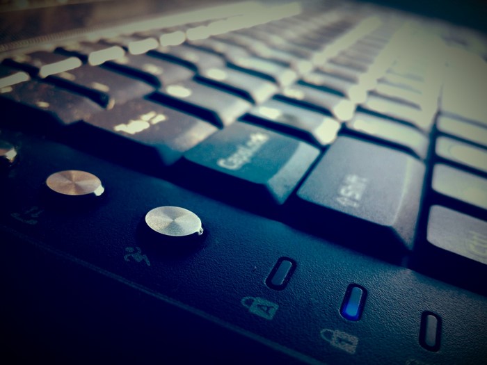 Close up of a black computer keyboard with blue lights