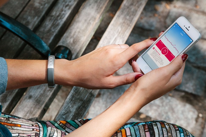 Woman checking Jawbone UP3 fitness tracker on smartphone