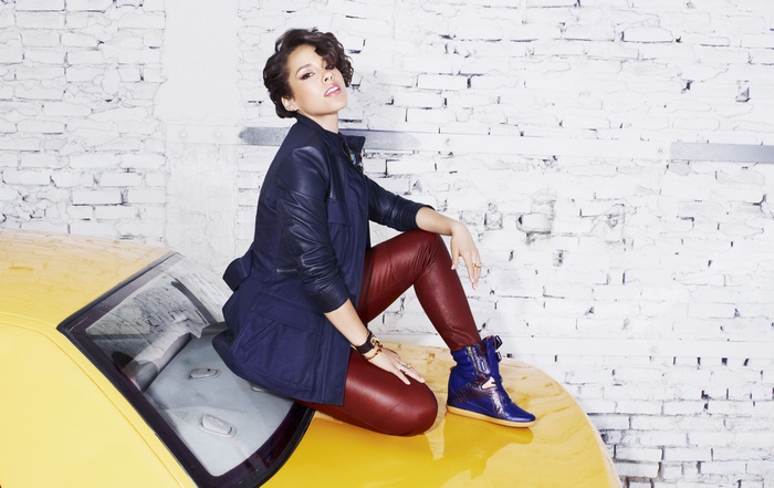 Alicia Keys sitting on a yellow car
