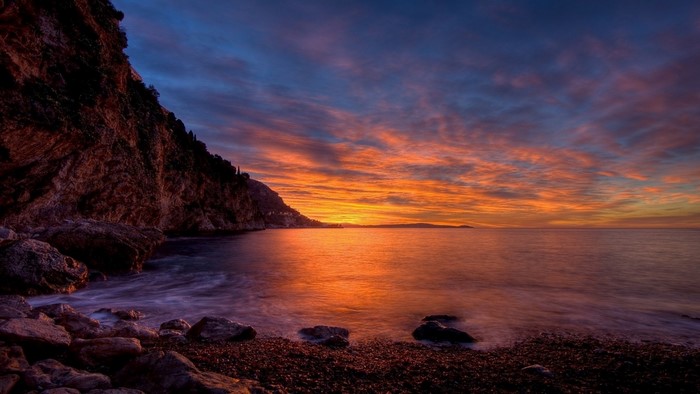 Serene Sunset over Rocky Coastal Bay