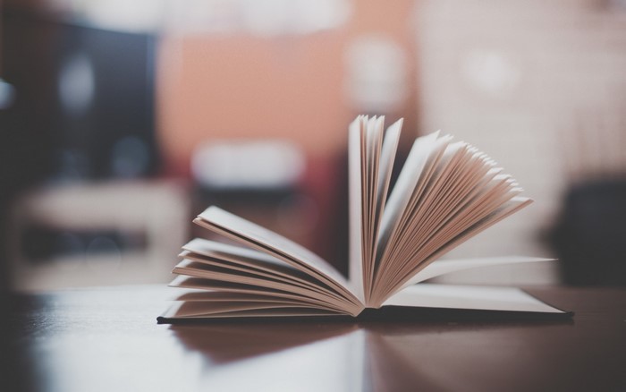 Open book with pages fanned out on a table