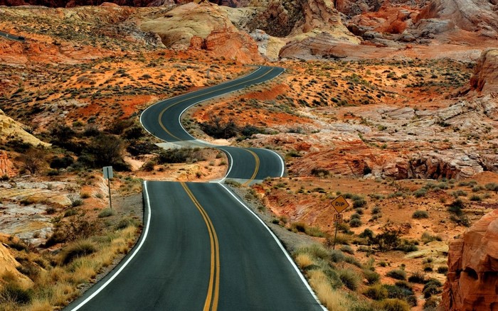 Winding road through a desert landscape with rock formations