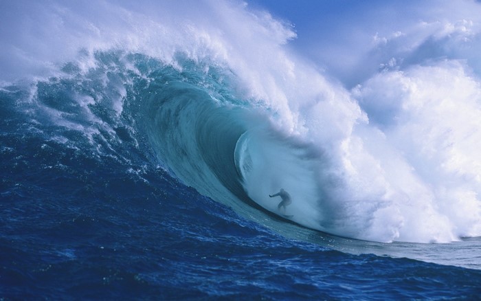 Surfer riding a massive ocean wave