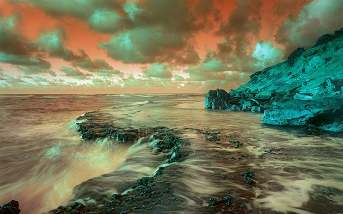 Ocean waves crashing on a rocky coast under a dramatic sky