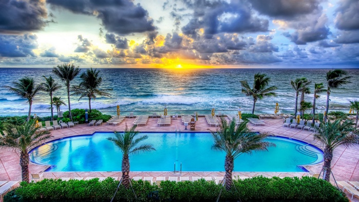 Resort swimming pool and ocean at sunrise