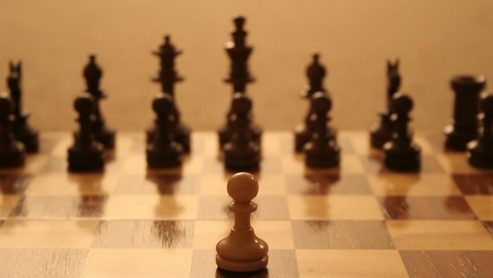 Chessboard with white pawn and black pieces