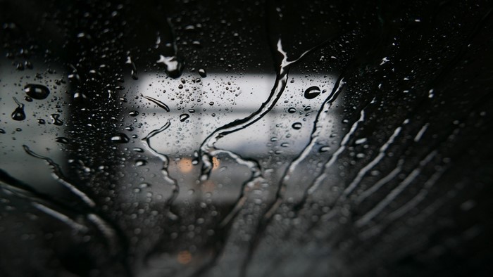 Water drops on glass, close-up monochrome photography