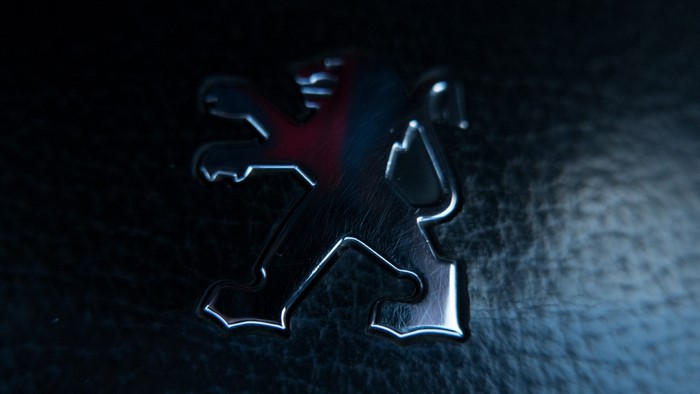 Peugeot lion logo emblem on black background