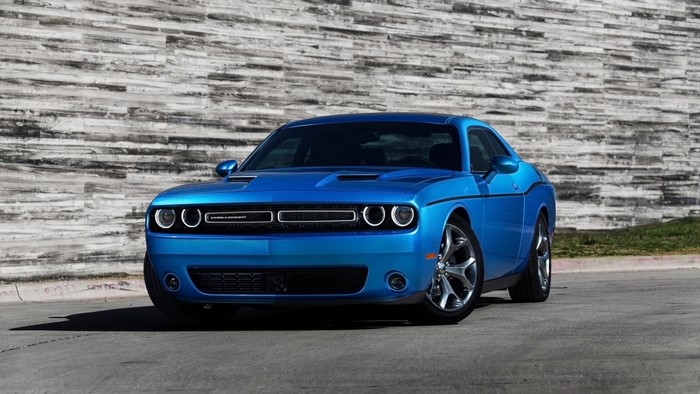 Blue Dodge Challenger parked in front of a stone wall