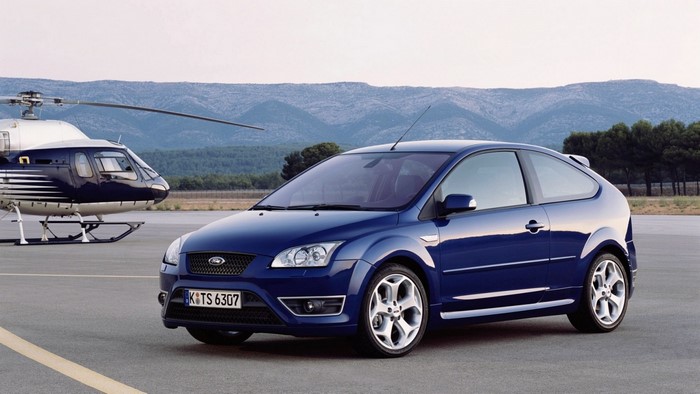 Blue Ford Focus ST parked next to a helicopter