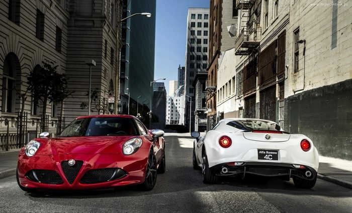 Red and white Alfa Romeo 4C sports cars on city street