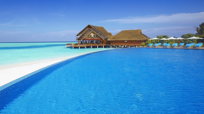 Infinity pool and overwater bungalows at a tropical resort