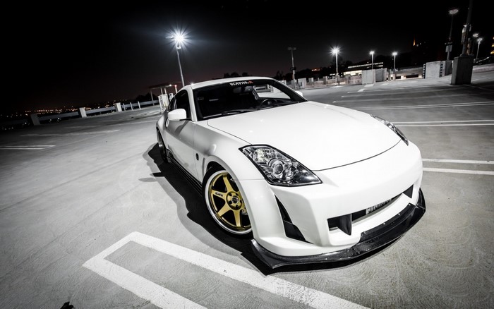 White Nissan 350Z sports car with gold wheels at night