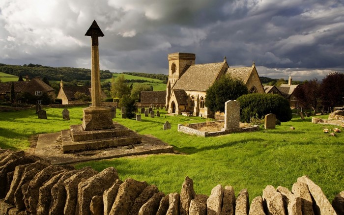 Village church and graveyard with stone cross