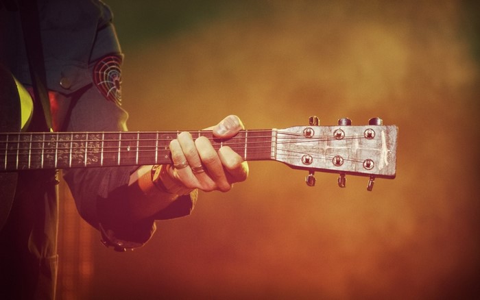 Close up of a person playing an acoustic guitar