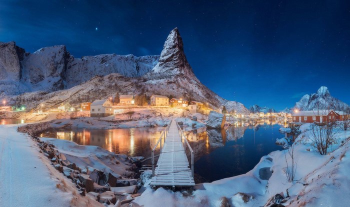 Winter village with mountains and bridge in Lofoten, Norway at night