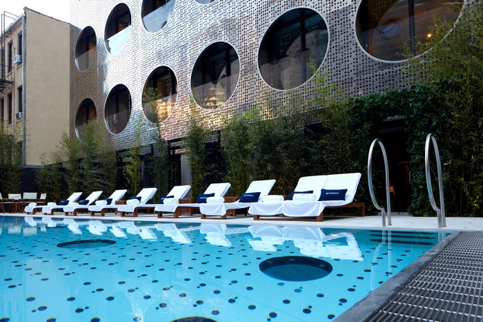 Dream Downtown Hotel Pool with Sunbeds and Modern Building