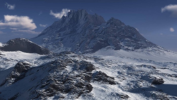Snowy mountain range under a blue sky with clouds
