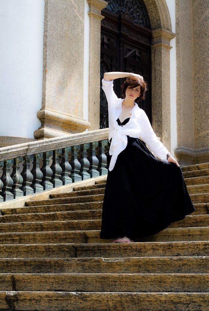 Woman in white shirt and black skirt on stairs