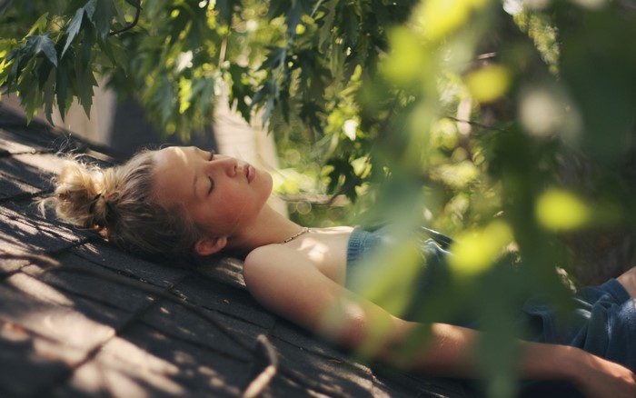 Girl sleeping on a roof with leaves