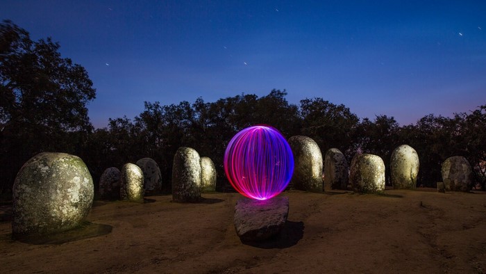 Light painting sphere among megaliths at night