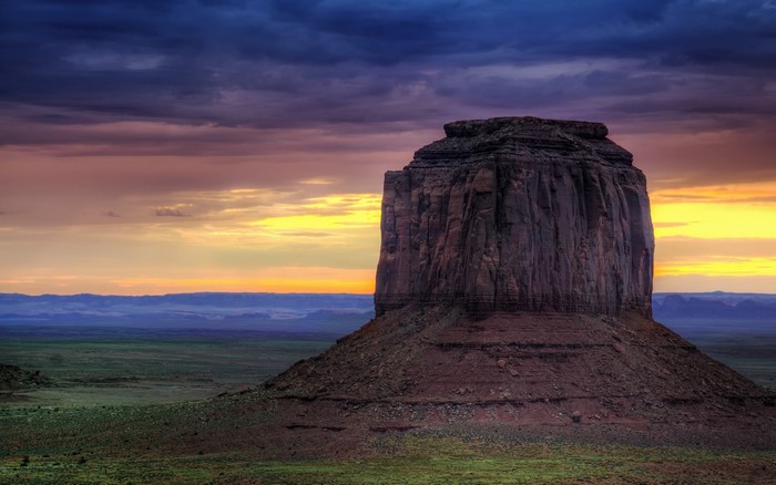 Monument Valley rock formation at sunset with colorful sky