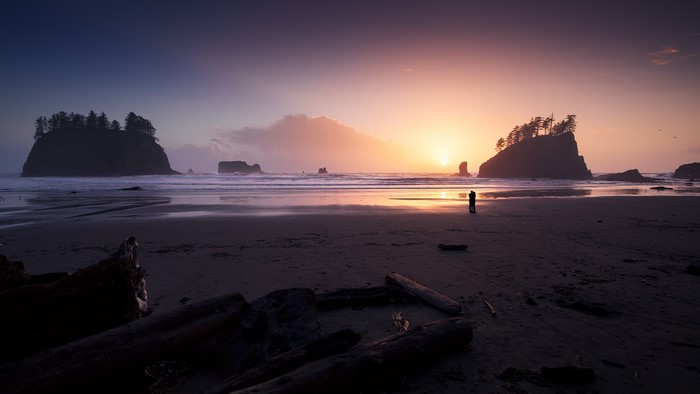 Sunset over the ocean with sea stacks and a couple