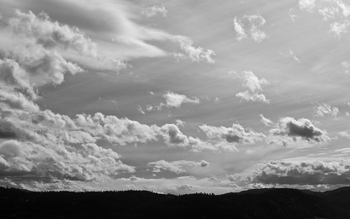 Monochrome landscape with dramatic clouds over hills